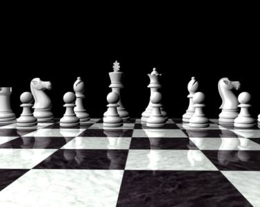 young men sitting on floor and playing chess on chess board